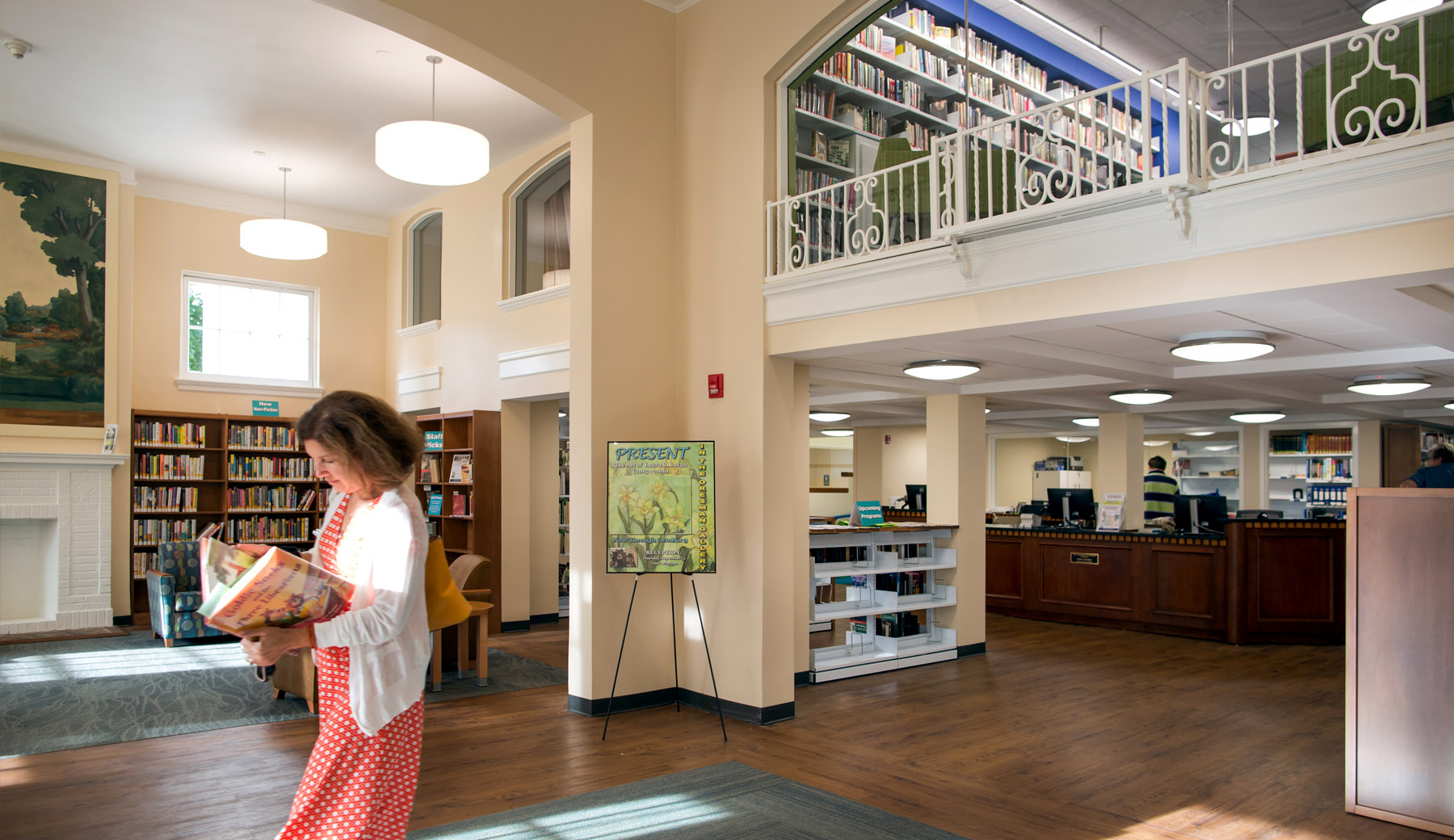 Interior View of Entry (Circulation Desk and Reading Areas):  A completely renovated library provides an appropriately sized circulation desk that is in plain sight of patrons entering the library. Appropriately furnished reading rooms, flanking a center aisle access to the circulation desk, provide comfortable and easily accessible quiet reading areas for adults.
