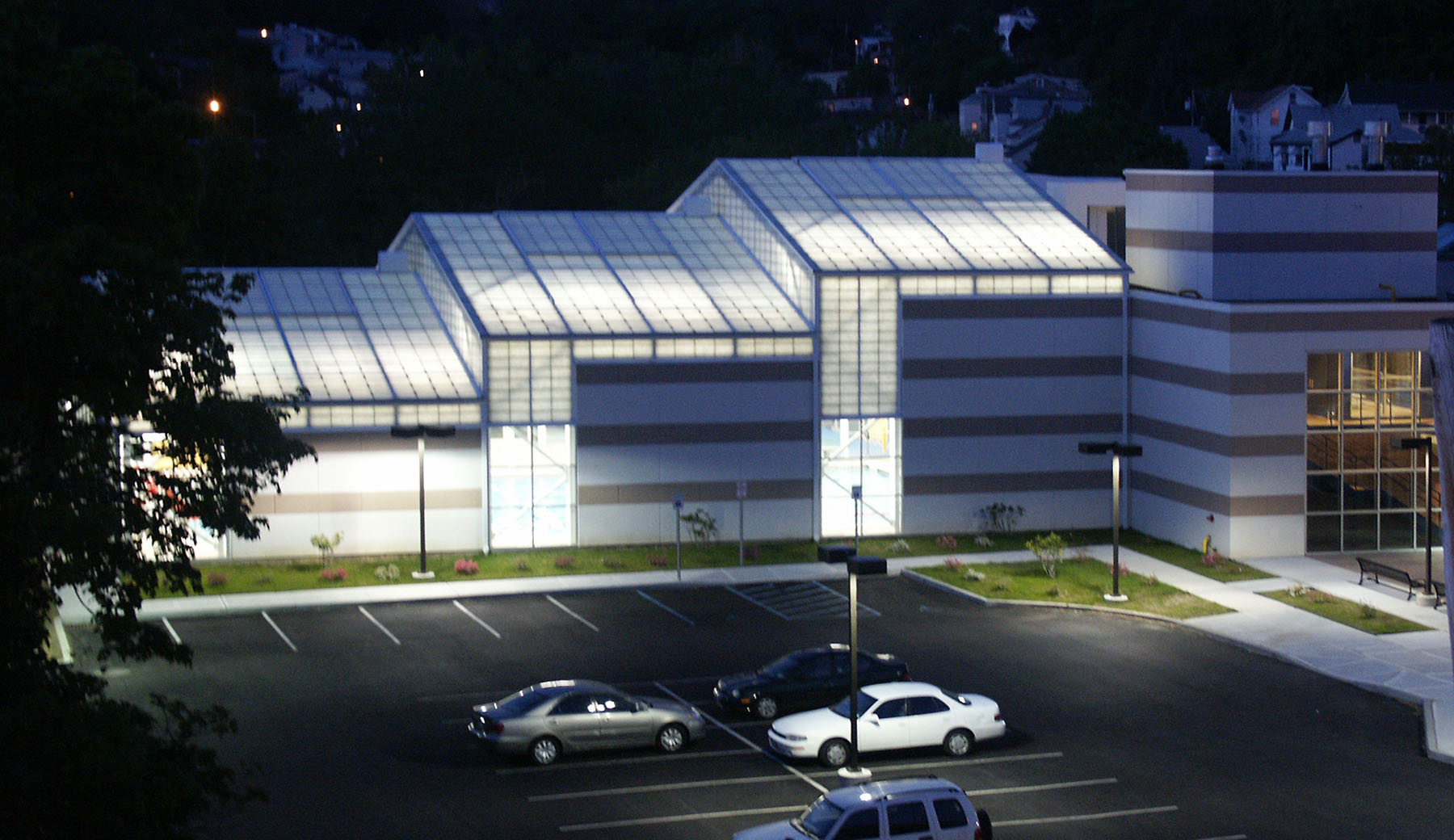 Operable Roof Panels Open to the Sky and Breezes. Translucent Panels Insulate the Natatorium and Glow in the Evening.