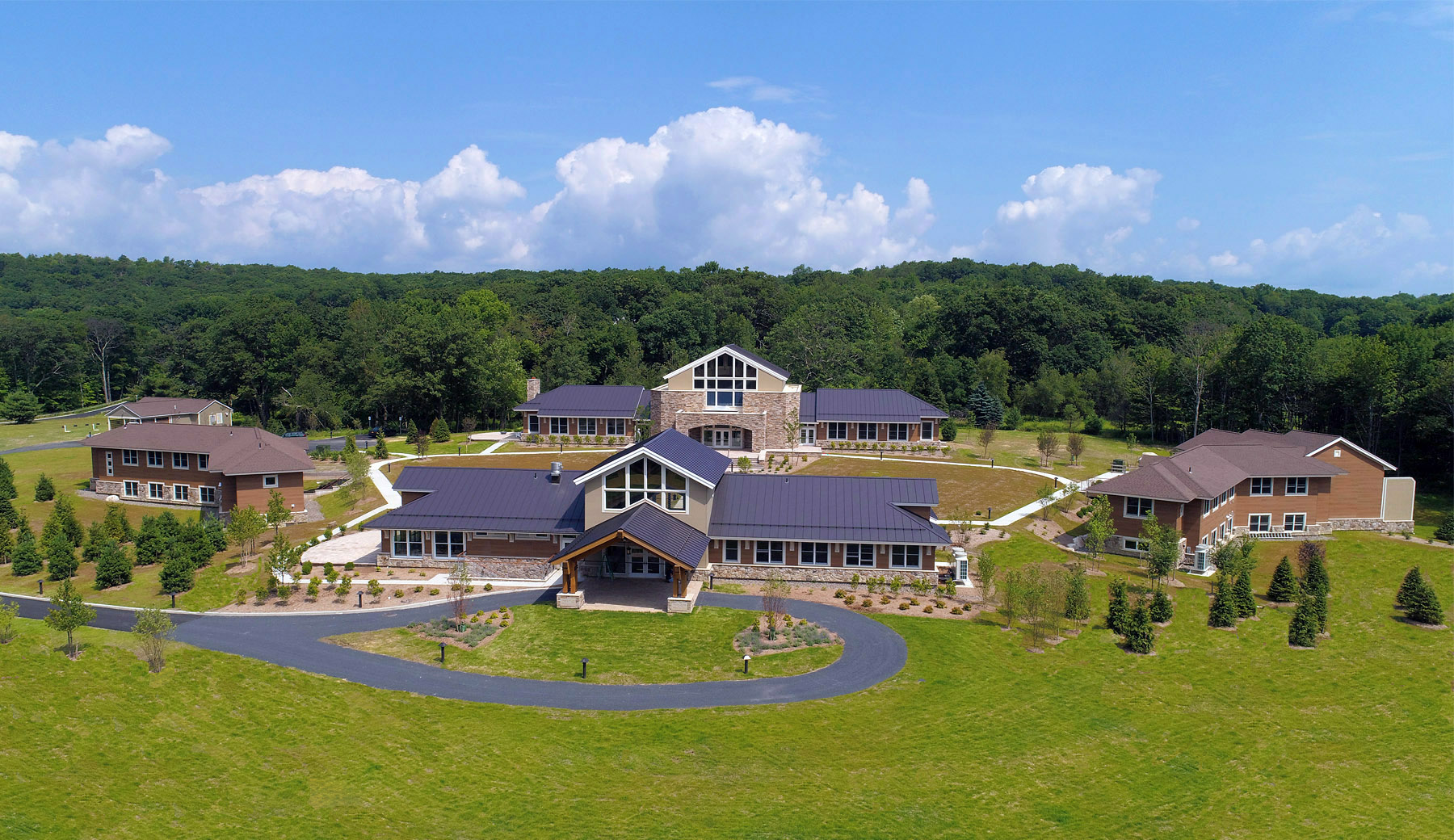 An aerial view of the Mahamudra Buddhist Hermitage in Pine Bush, New York. The Welcome Center is front and center with the Meditation Hall beyond and Residence buildings flanking either side.