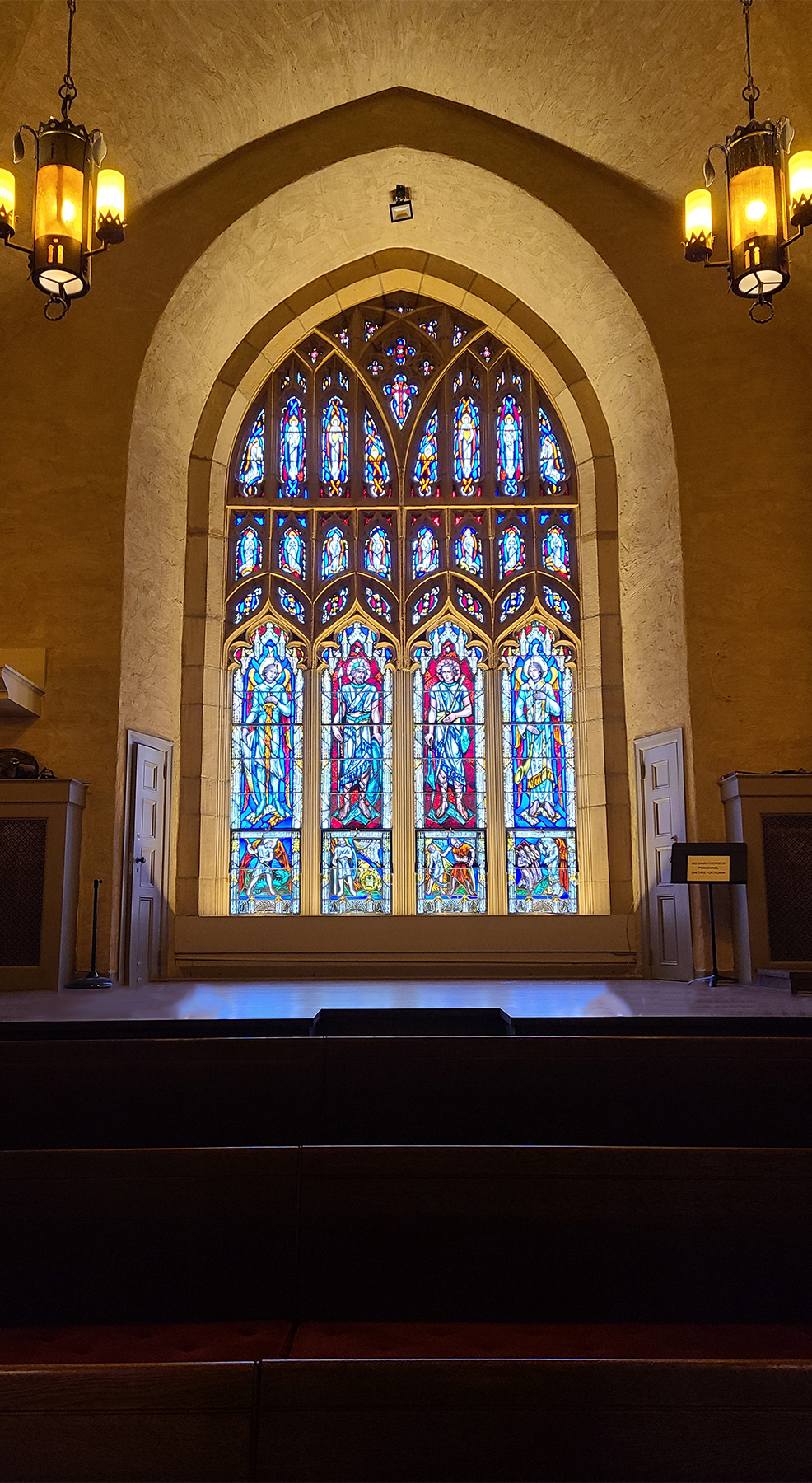 Closeup view of restored choir loft plaster and stained-glass window.